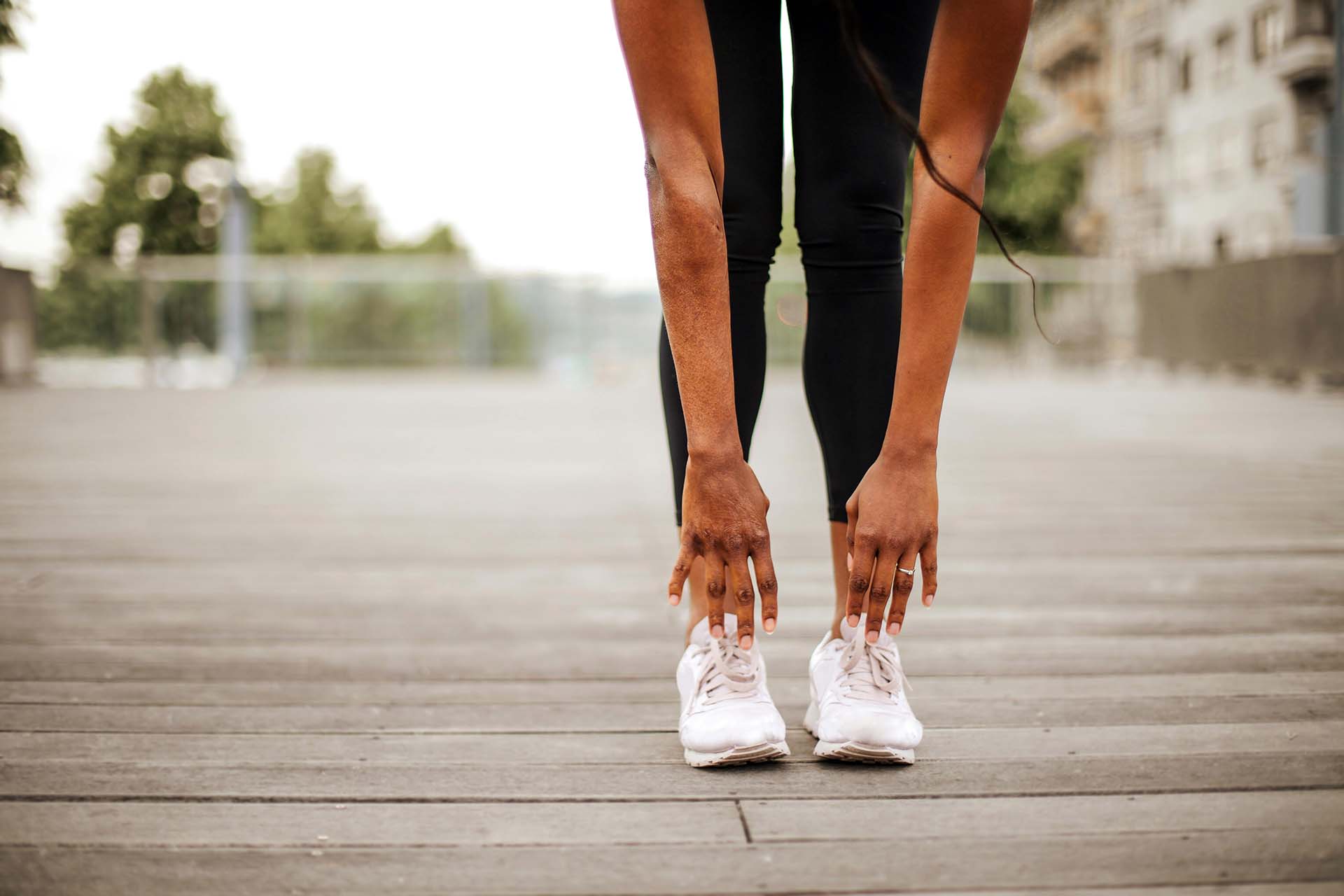 woman's hands stretching to touch her toes