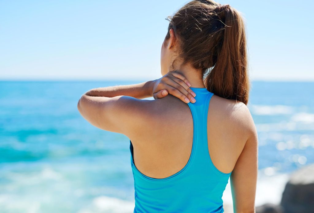 woman touching neck in pain