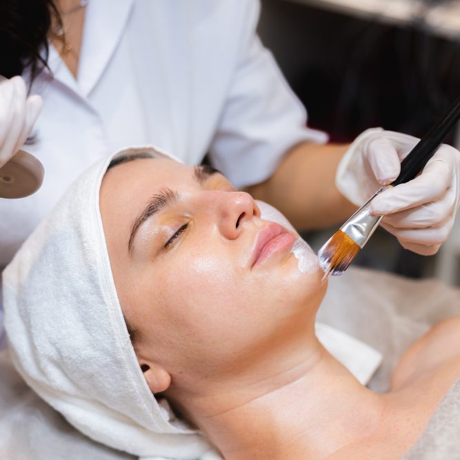 woman with eyes closed receiving facial treatment
